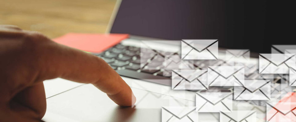 Composite image of hand using laptop put on a desk with letter icons