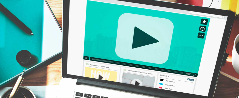 Hand typing on laptop with play button on screen