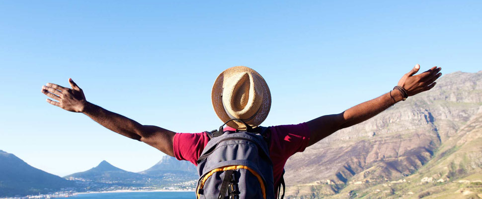 Young man on holiday standing with arms spread open Young man on holiday standing with arms spread open