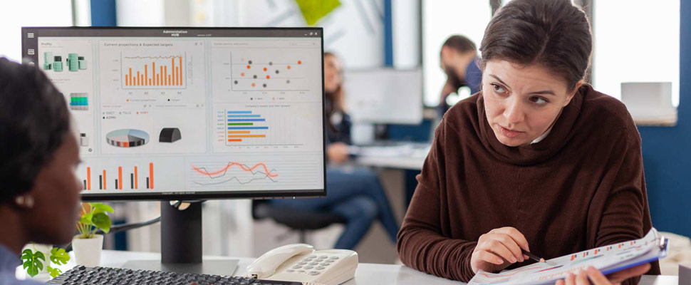 Diverse businesswomen planning financial strategy looking on computer Diverse businesswomen planning financial strategy looking on computer