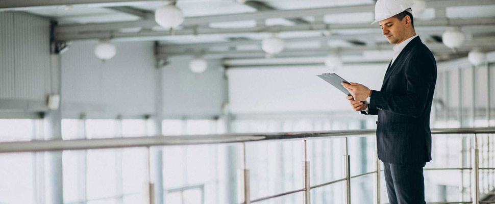 Handsome business man engineer in hard hat in a building Handsome business man engineer in hard hat in a building