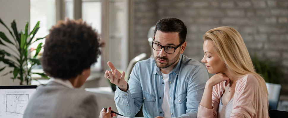 Couple advising with insurance agent about their financial repor Couple advising with insurance agent about their financial repor