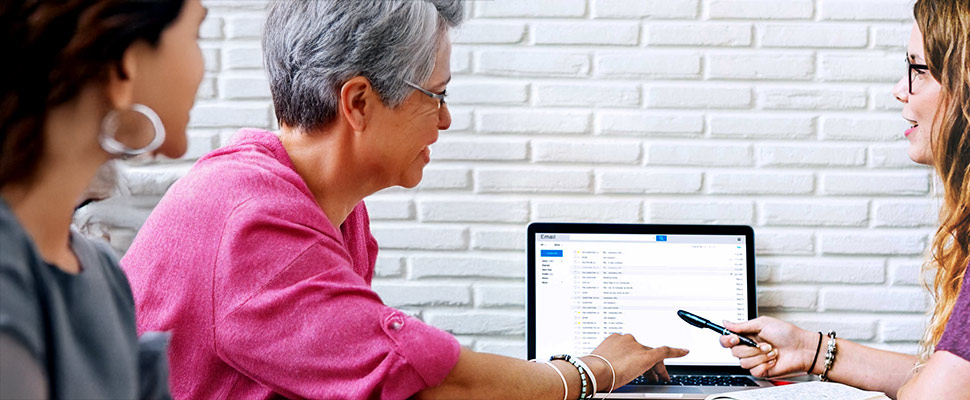 Closeup of friends working with computer laptop together Closeup of friends working with computer laptop together