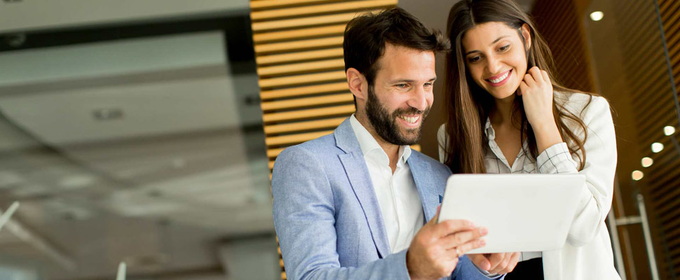 Handsome young couple with tablet in the modern office