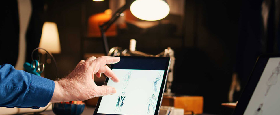 Old couturier checking fashion sketches